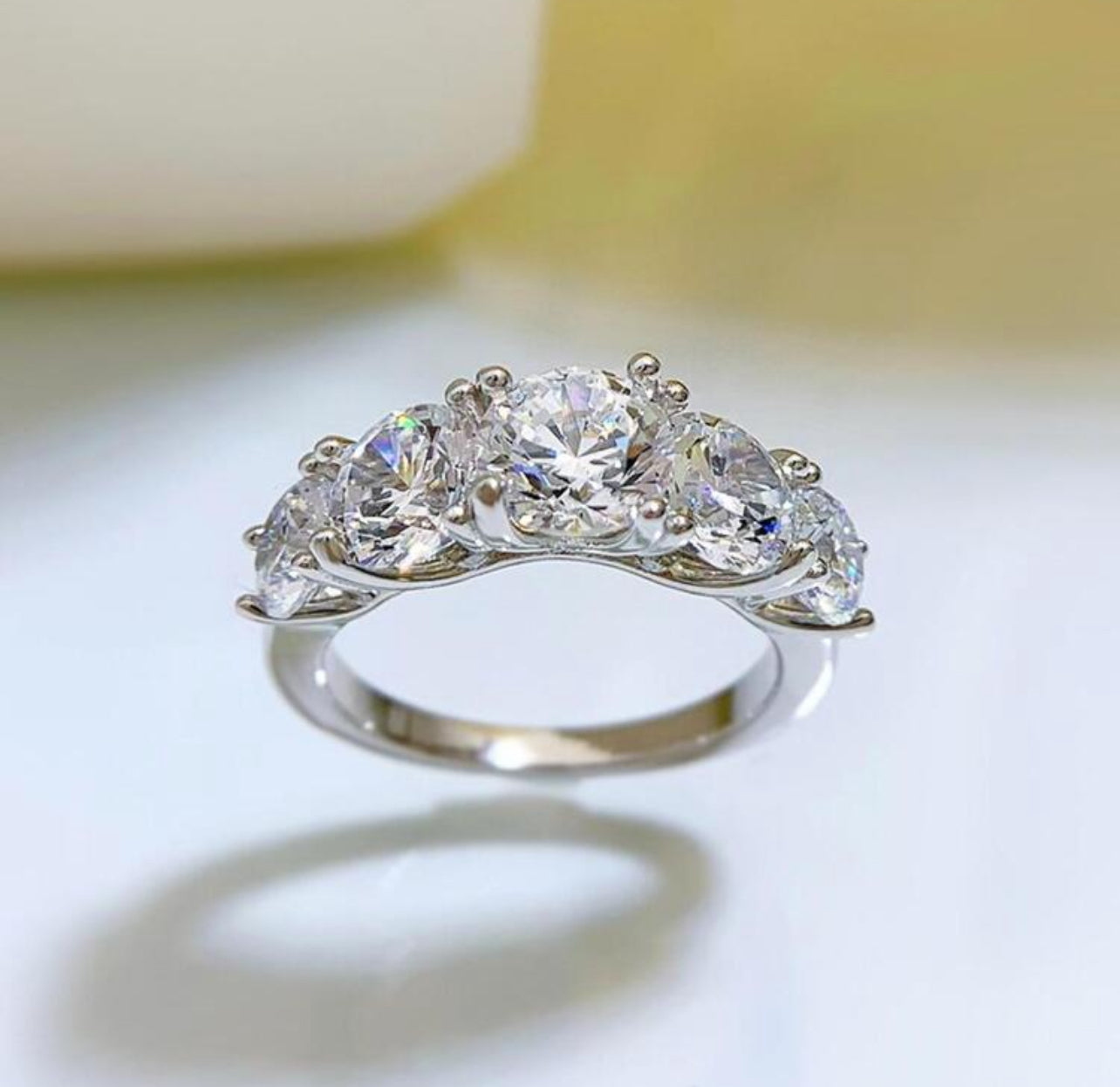 Meia Aliança Aparador Lumiére com 5 Pedras em Moissanite com corte redondo,Prata 925, cor D-E, pureza VVS1, com pedras de 6,5mm, 6mm e 5mm, acompanhada de Certificado GRA da pedra central de 6,5mm. Prata 925 banho ouro Branco 18 K e Ouro Amarelo 18 k