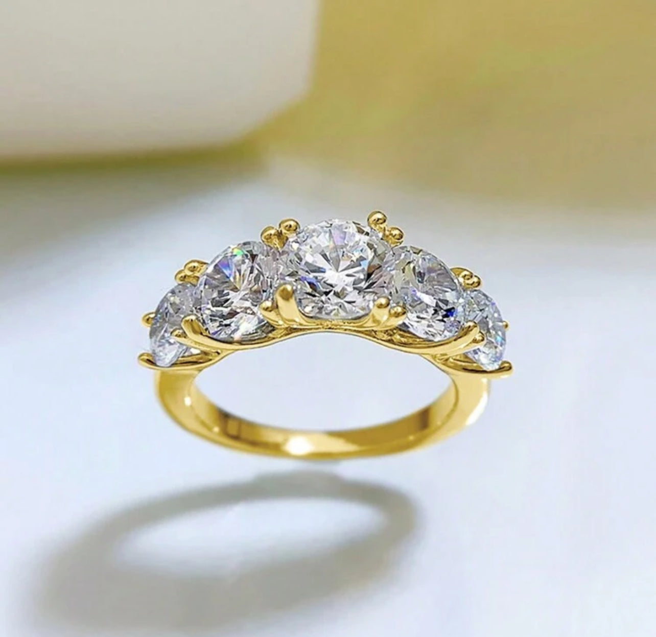 Meia Aliança Aparador Lumiére com 5 Pedras em Moissanite com corte redondo,Prata 925, cor D-E, pureza VVS1, com pedras de 6,5mm, 6mm e 5mm, acompanhada de Certificado GRA da pedra central de 6,5mm. Prata 925 banho ouro Branco 18 K e Ouro Amarelo 18 k